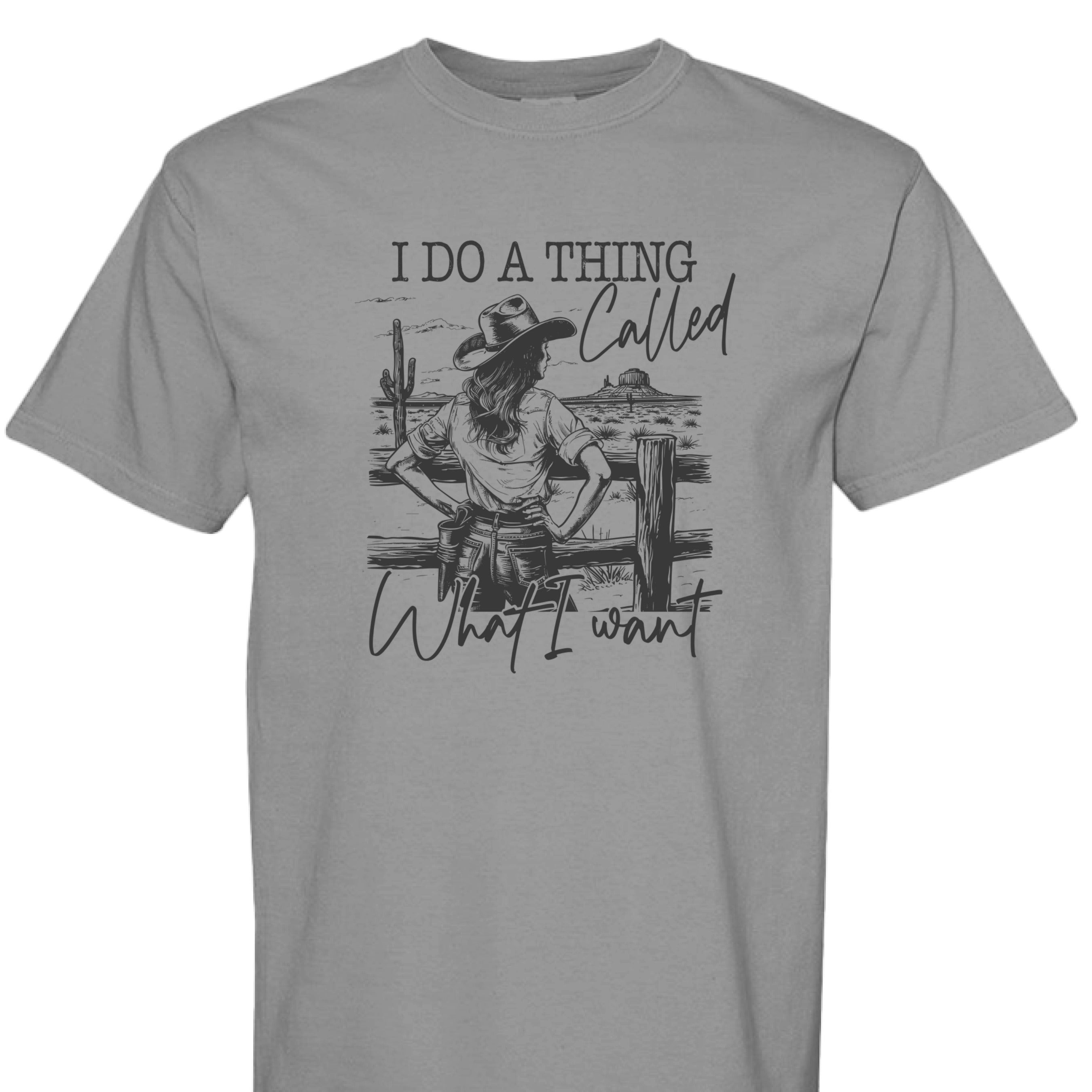 GREY - FRONT = I Do a Thing Called What I Want western shirt with cowgirl in hat and boots leaning on fence in desert landscape.