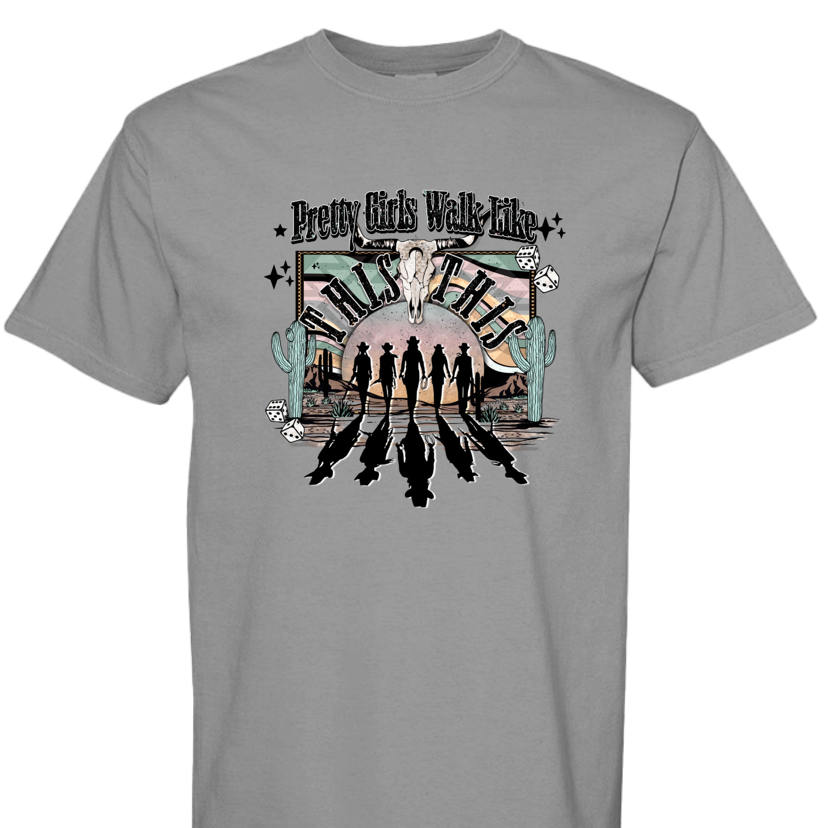 GREY - FRONT - Western graphic T-shirt design with cowgirl silhouettes, steer skull, desert sunset, dice, and text Pretty Girls Walk Like This.